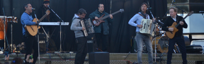 foto músicos en escenario dos acordeonistas y tres guitarras y bajo