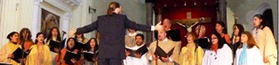 recorte foto del coro de la uner-concordia se ve a su director de espaldas, es decir frente al coro en un escenario